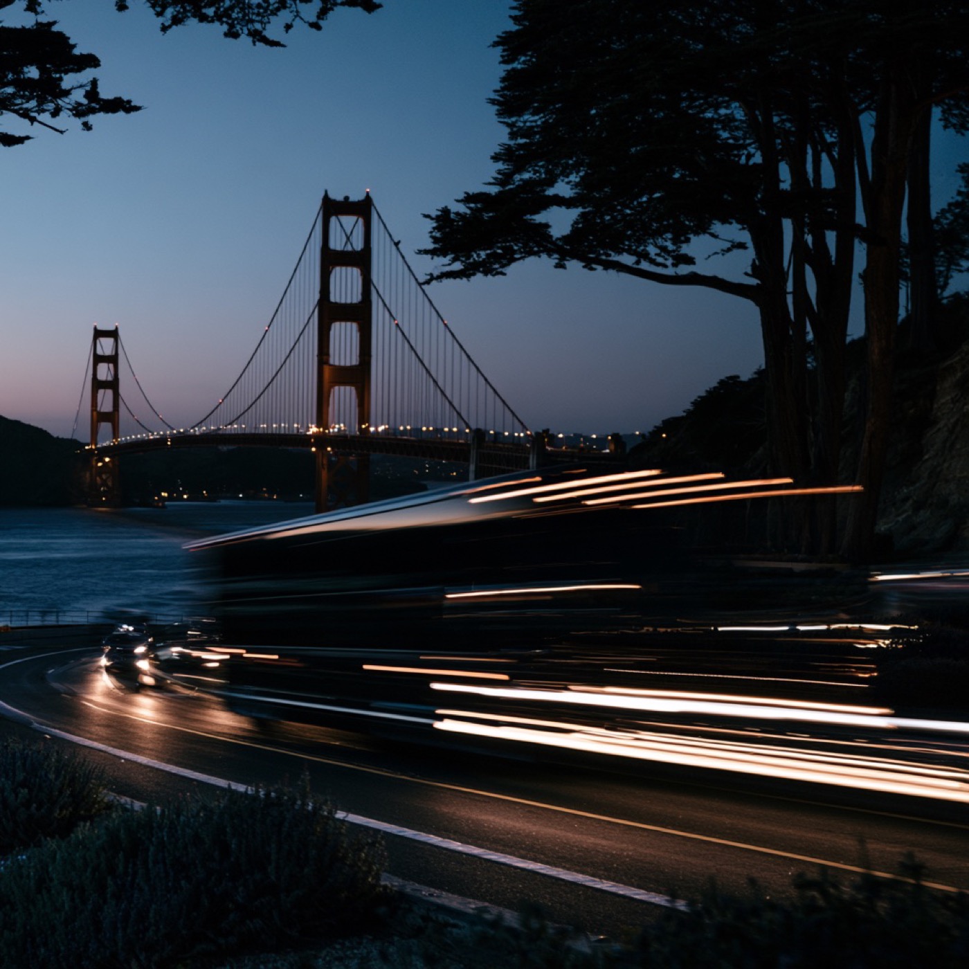 Evening traffic streaking past the Golden Gate Bridge