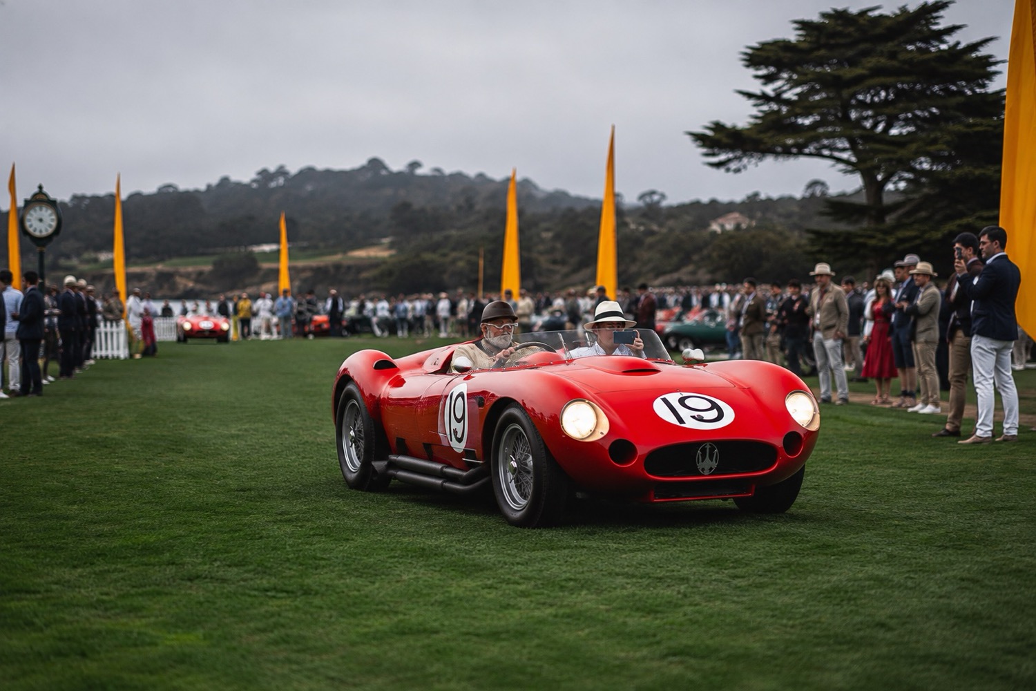 Vintage red Maserati race car driving the fairway at the Pebble Beach Concours